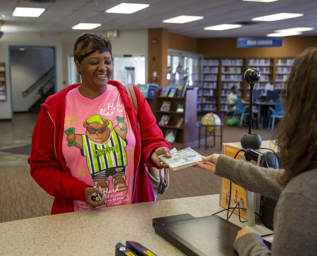 A woman checks out her next book to read from the library.